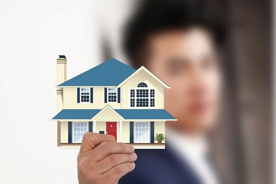A Man is Holding a House