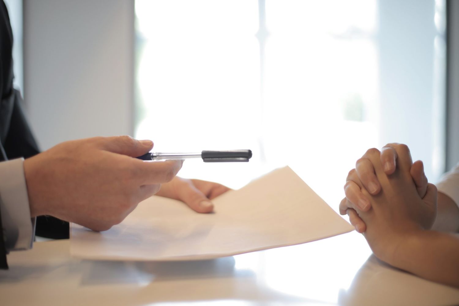 A Lender handing a loan application document for an individual to sign