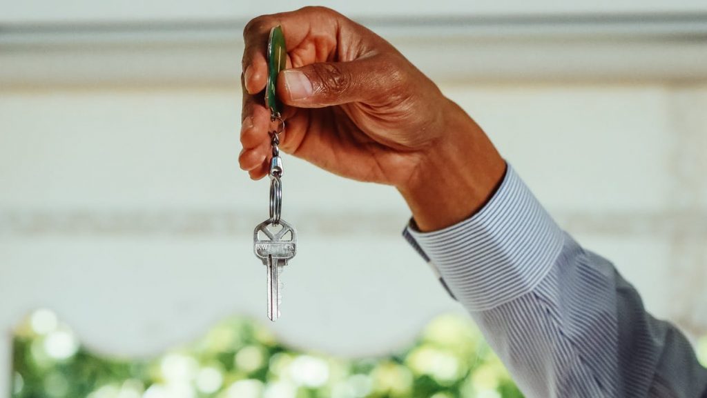 A man’s hand holding house keys