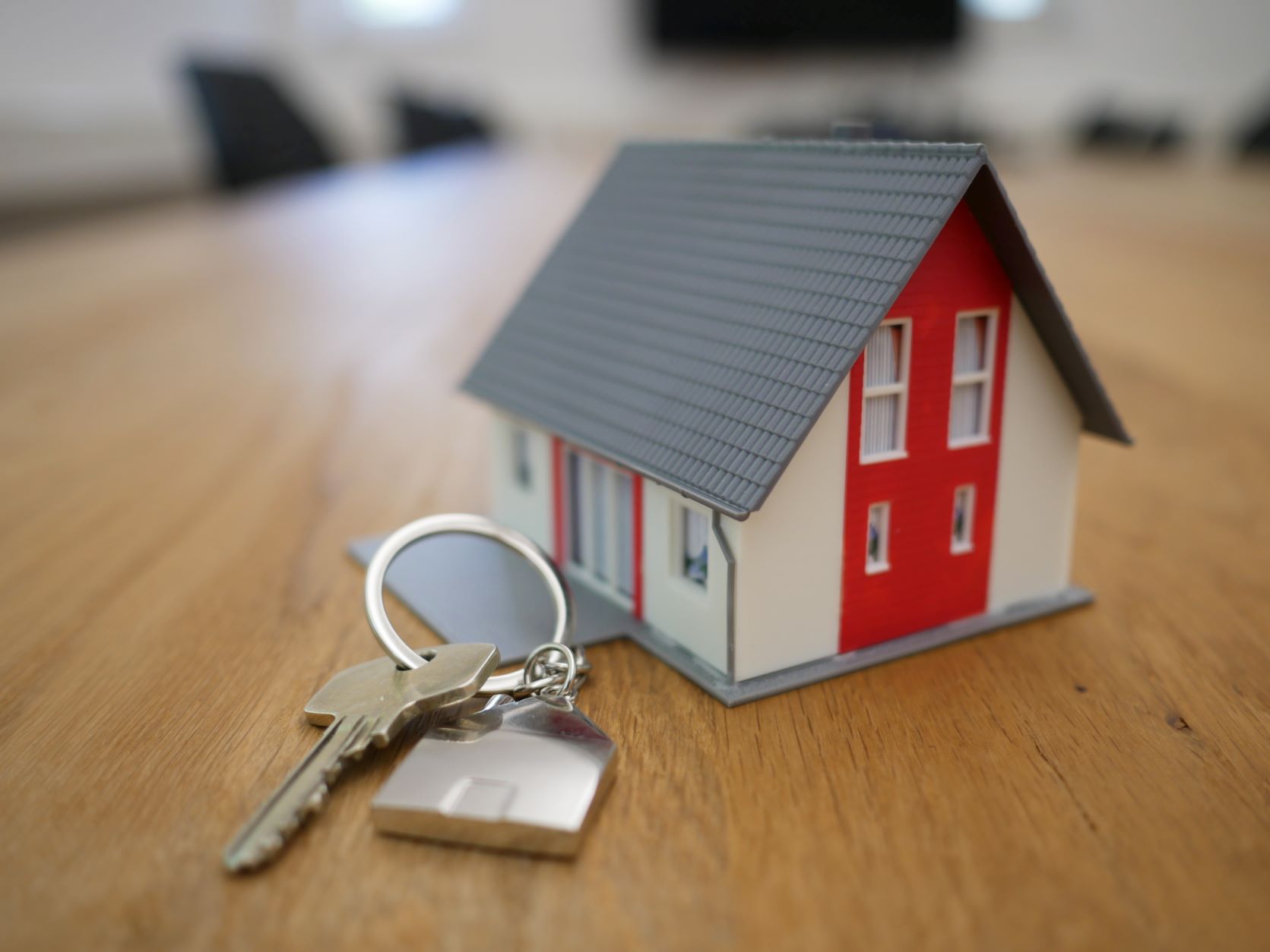 Miniature house with house keys next to it