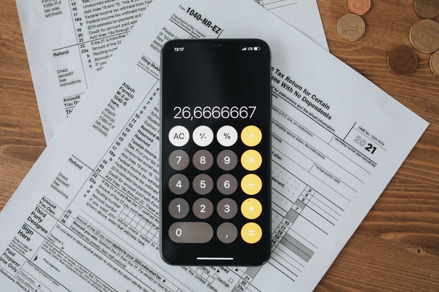 Tax forms with calculator on wooden surface