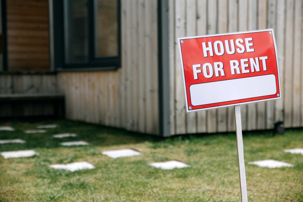 a house for rent sign in front of a property